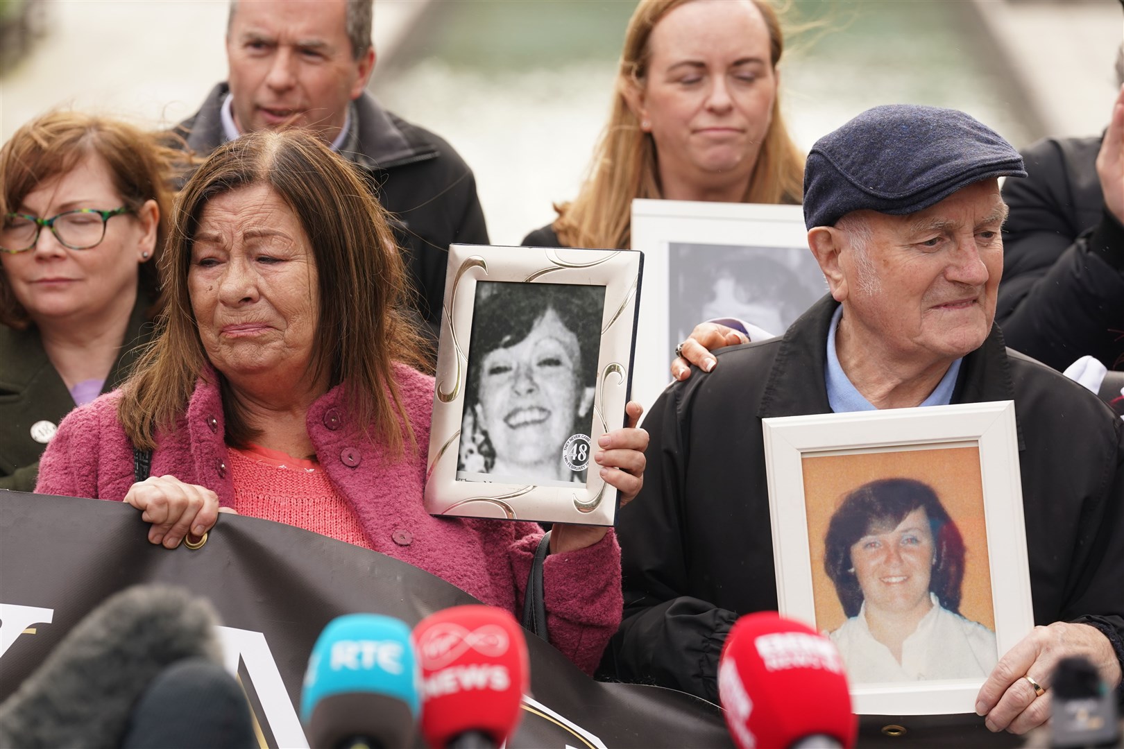 Survivors, family members and supporters hold pictures of those they lost (Brian Lawless/PA)